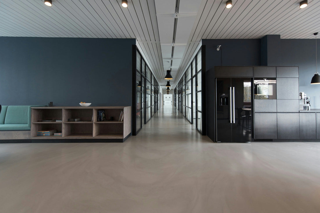 A short open wooden bookcase in a modern office space adjacent to a hallway as one of the used office storage solutions