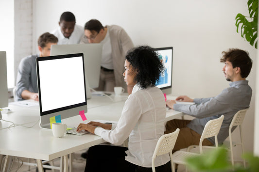 A diverse team is working at a modern office workstation furniture setup.
