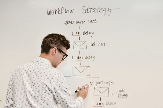 Close up of a man writing on a glass whiteboard