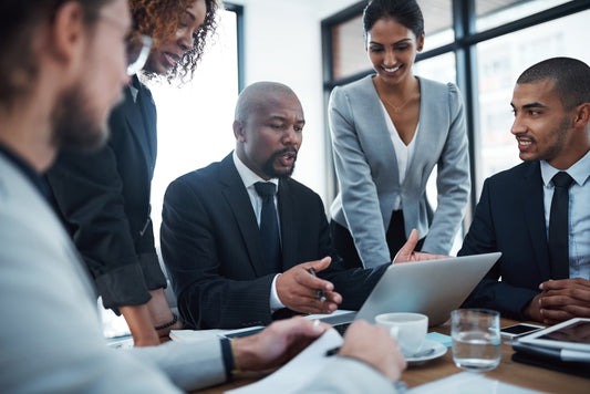 A high performance team gathered around a board room table to collaborate.