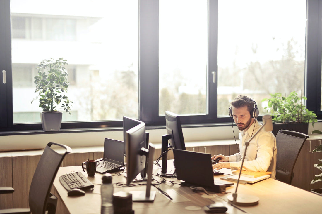 Bright office space with ergonomic office furniture and large windows and plants
