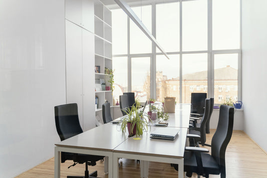 A small office meeting room, overlooking a city, fitted with modern office workstations